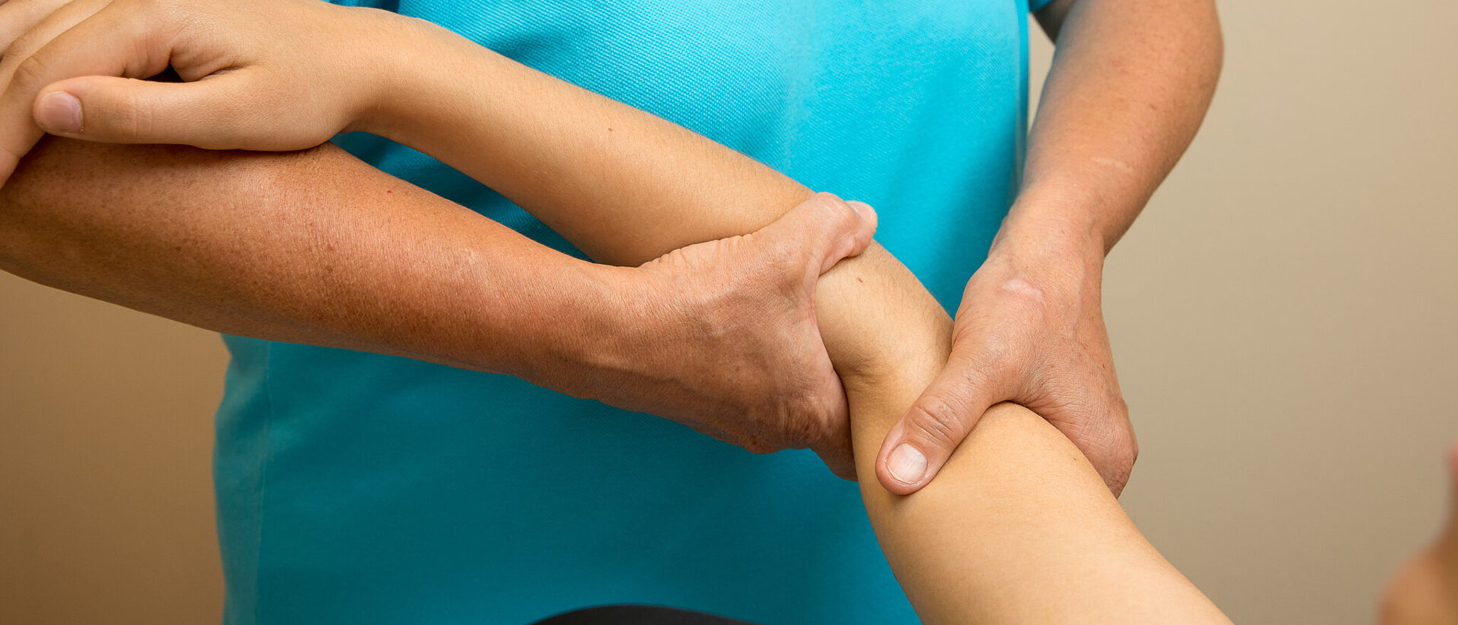 Physiotherapeutin mobilisiert den Arm einer Patientin